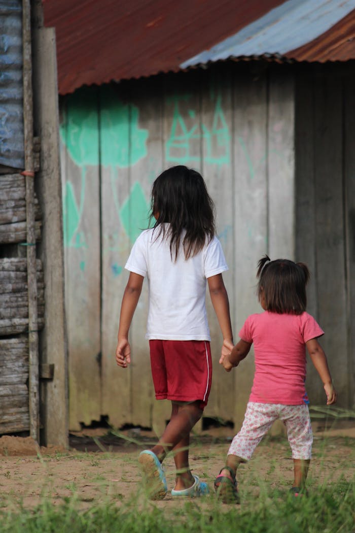 A Young Boy and Young Girl Walking while Holding Hands
